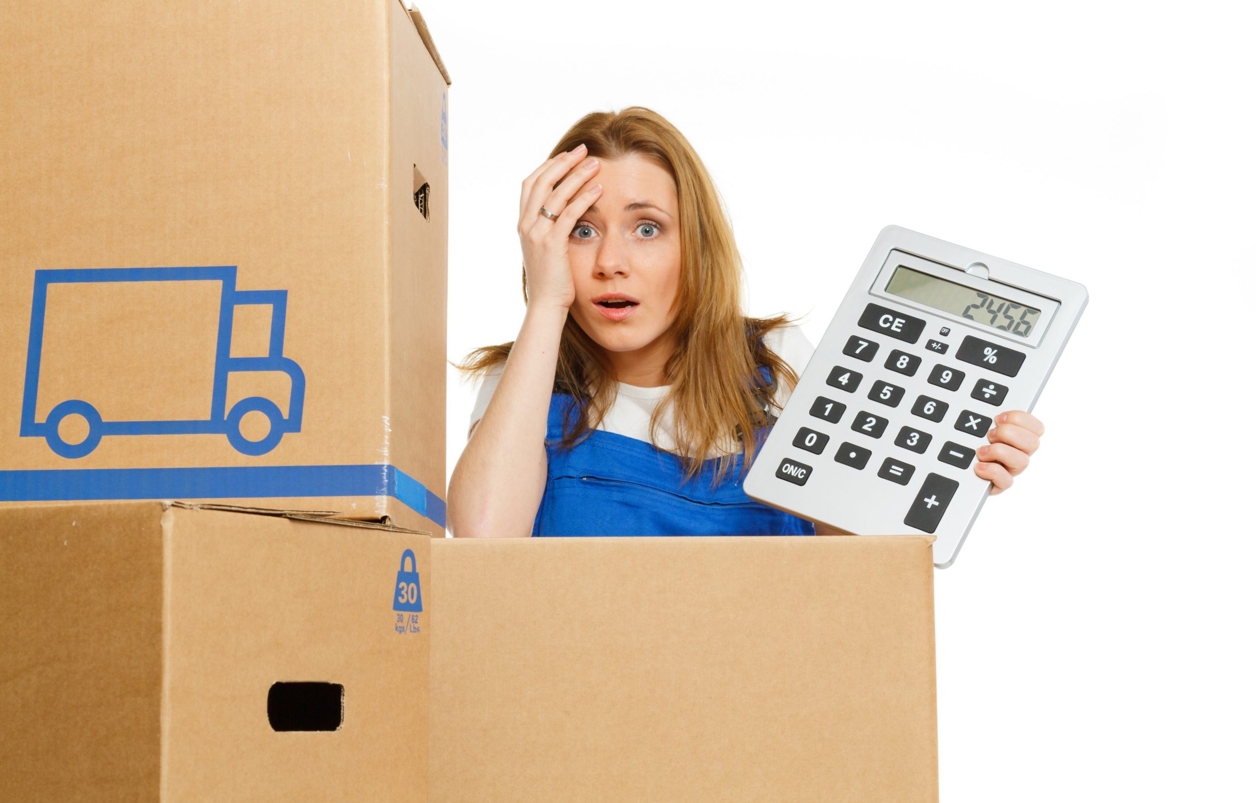 Woman holding a calculator beside moving boxes