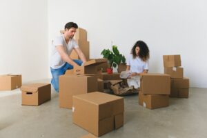 Couple packing boxes in an emptied apartment