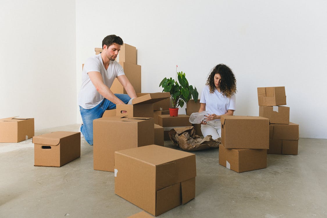 Couple packing boxes in an emptied apartment