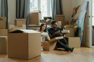 Couple sitting among packed boxes during a move