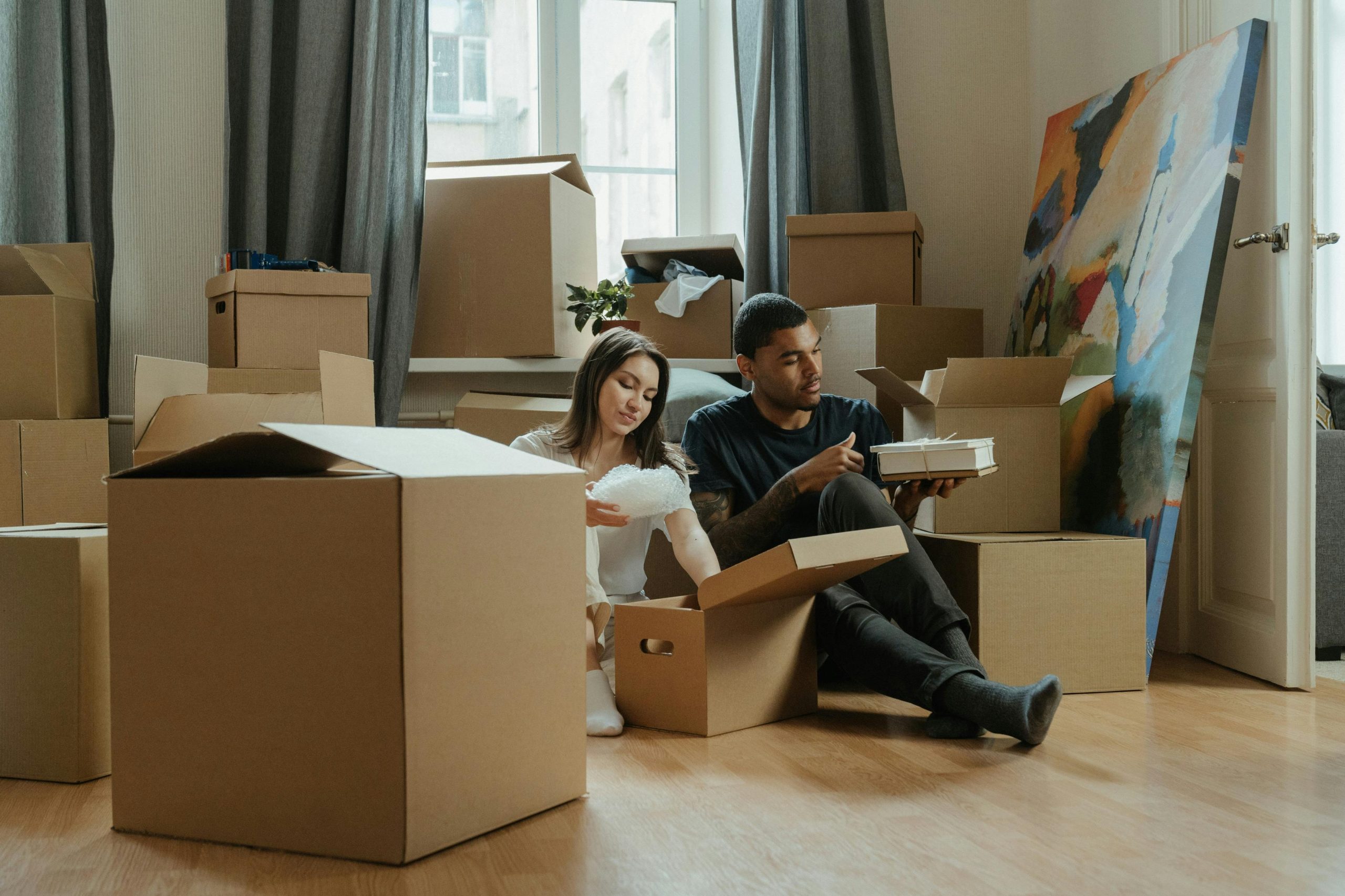Couple sitting among packed boxes during a move