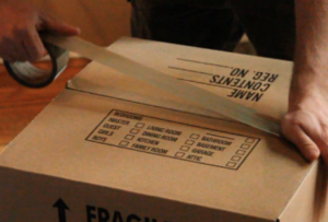 Taping and labelling a box marked fragile before a move